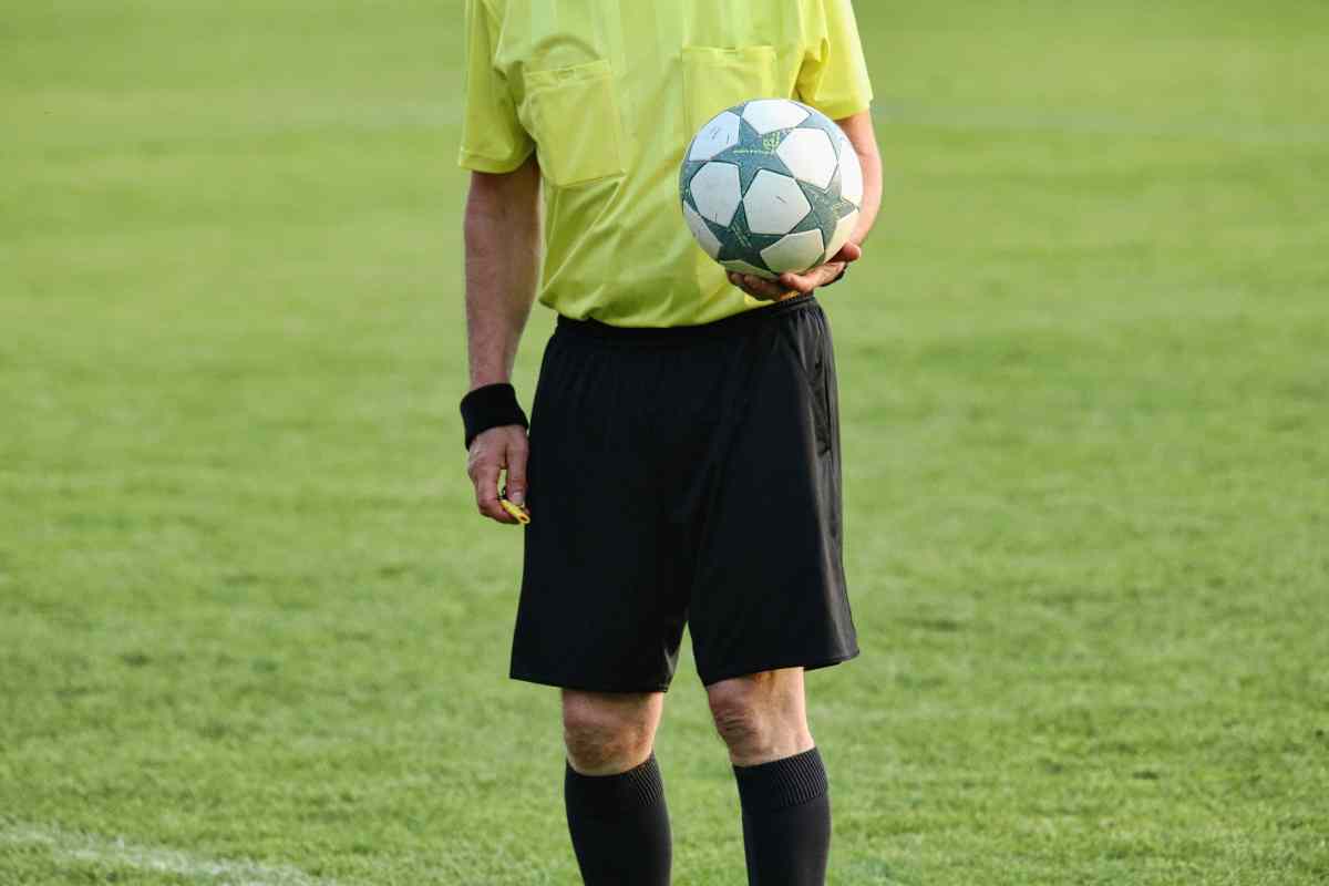 Arbitro di calcio con il pallone in mano